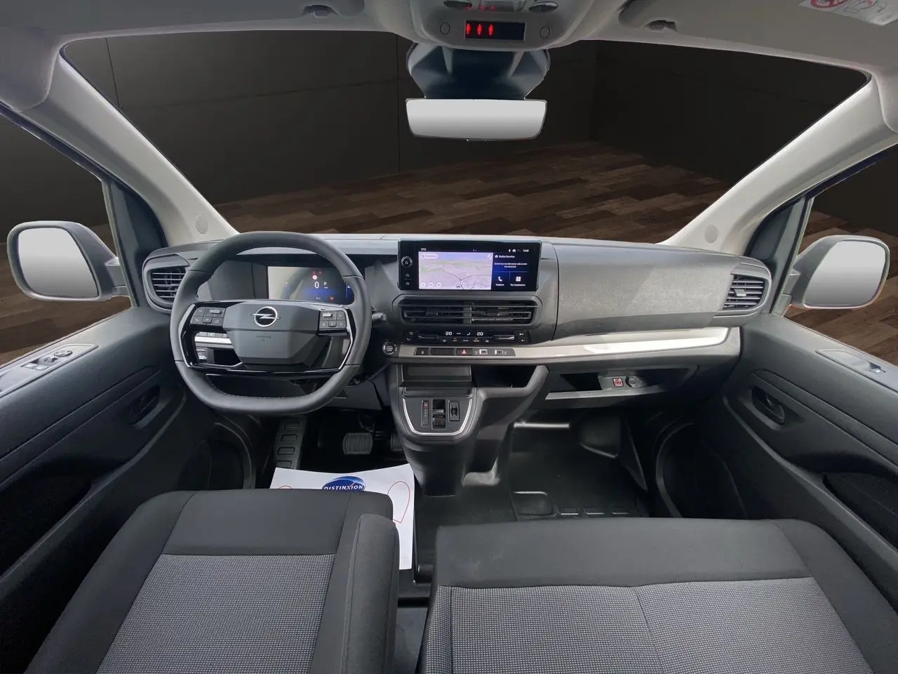 Vue intérieure avant de l'Opel Vivaro 2025, tableau de bord moderne avec écran tactile et volant multifonction noir.