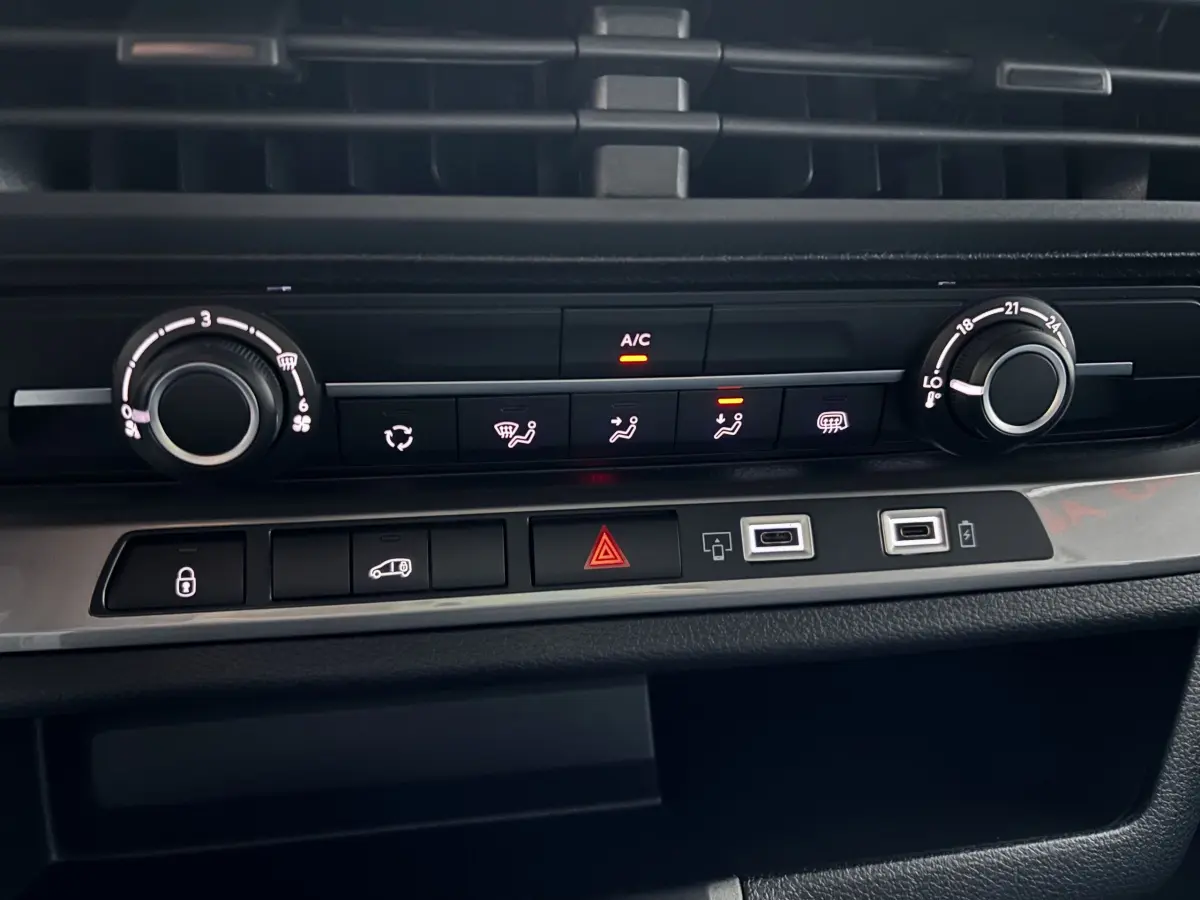 Gros plan sur la console centrale du Peugeot Expert Fourgon blanc 2025, montrant les commandes de climatisation et ports USB.