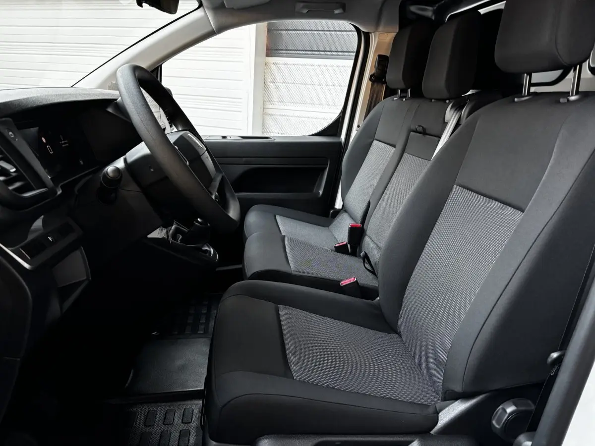 Vue intérieure côté conducteur du Peugeot Expert Fourgon 2025 avec sièges tissu gris et volant multifonctions.