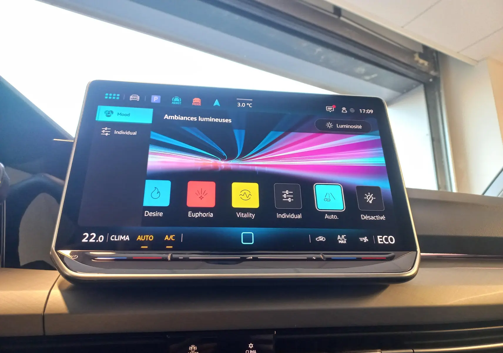 Écran tactile central de la Volkswagen Golf 1.5 eHybrid 2025 affichant les ambiances lumineuses, intérieur moderne et épuré.