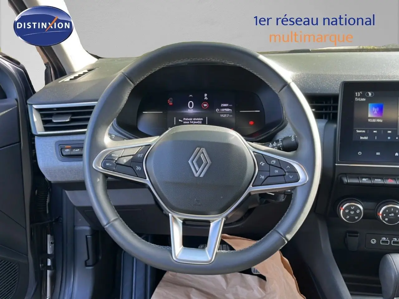 Vue intérieure centrée sur le volant multifonction de la Renault Clio 2025 avec tableau de bord numérique et console centrale.
