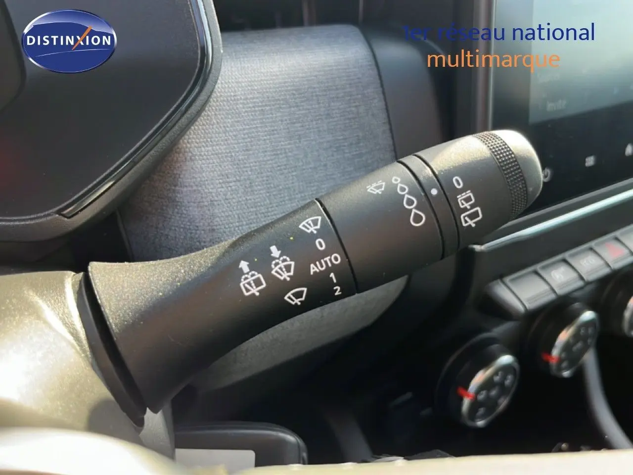 Gros plan sur la commande d’essuie-glace à gauche du volant dans l’habitacle d’une Renault Clio gris schiste métal.