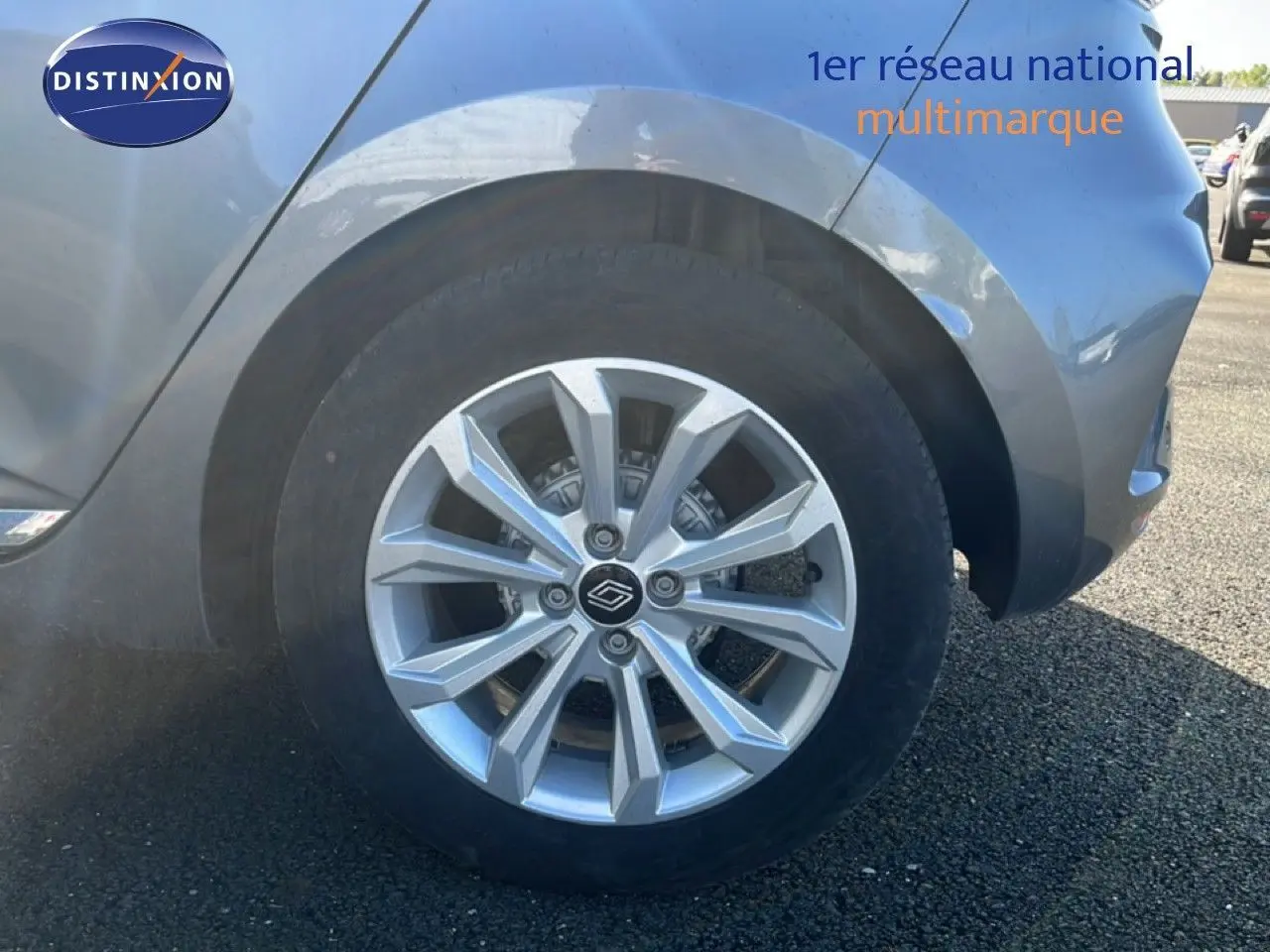 Gros plan sur la roue avant droite d’une Renault Clio gris schiste métal, mettant en valeur la jante alu moderne.