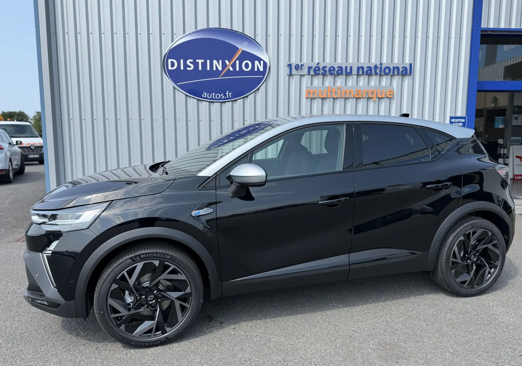 Profil côté gauche du Renault Captur 1.6 E-TECH hybride noir étoile avec toit gris et jantes noires distinctives.