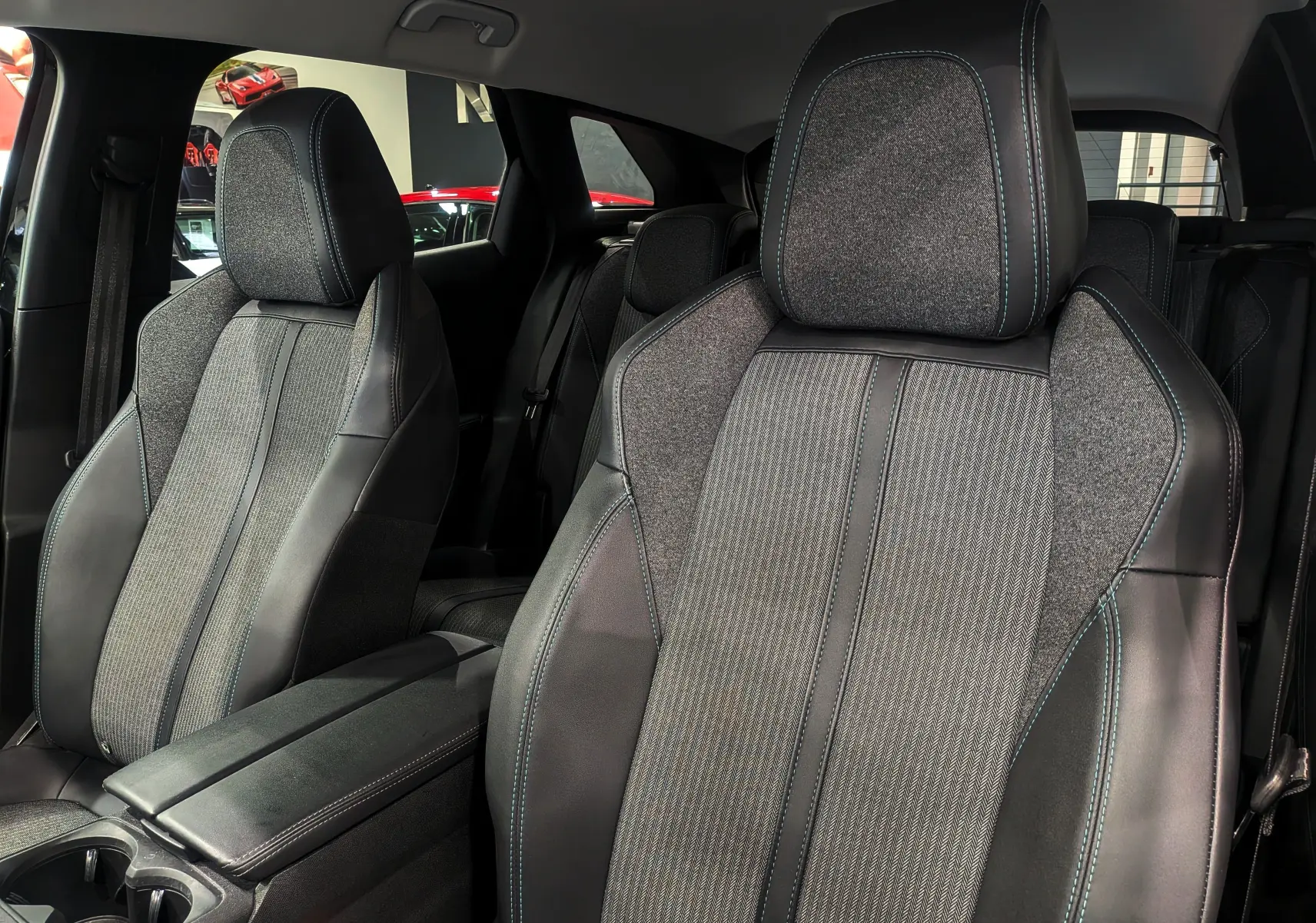 Gros plan sur les sièges avant en tissu gris et cuir noir avec surpiqûres bleues du Peugeot 3008 BlueHDi 130 Allure 2022.