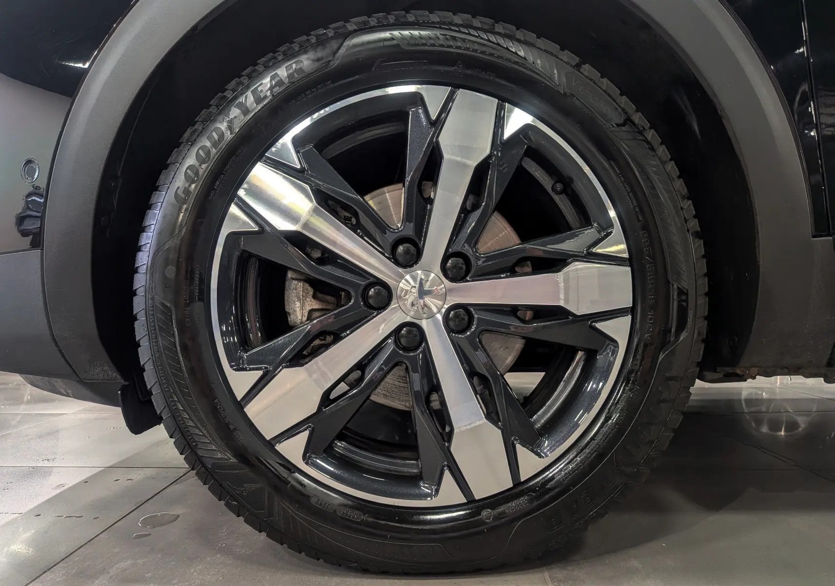 Gros plan sur la jante bi-ton noire et argentée du Peugeot 3008 Noir Perla, pneu Goodyear visible.