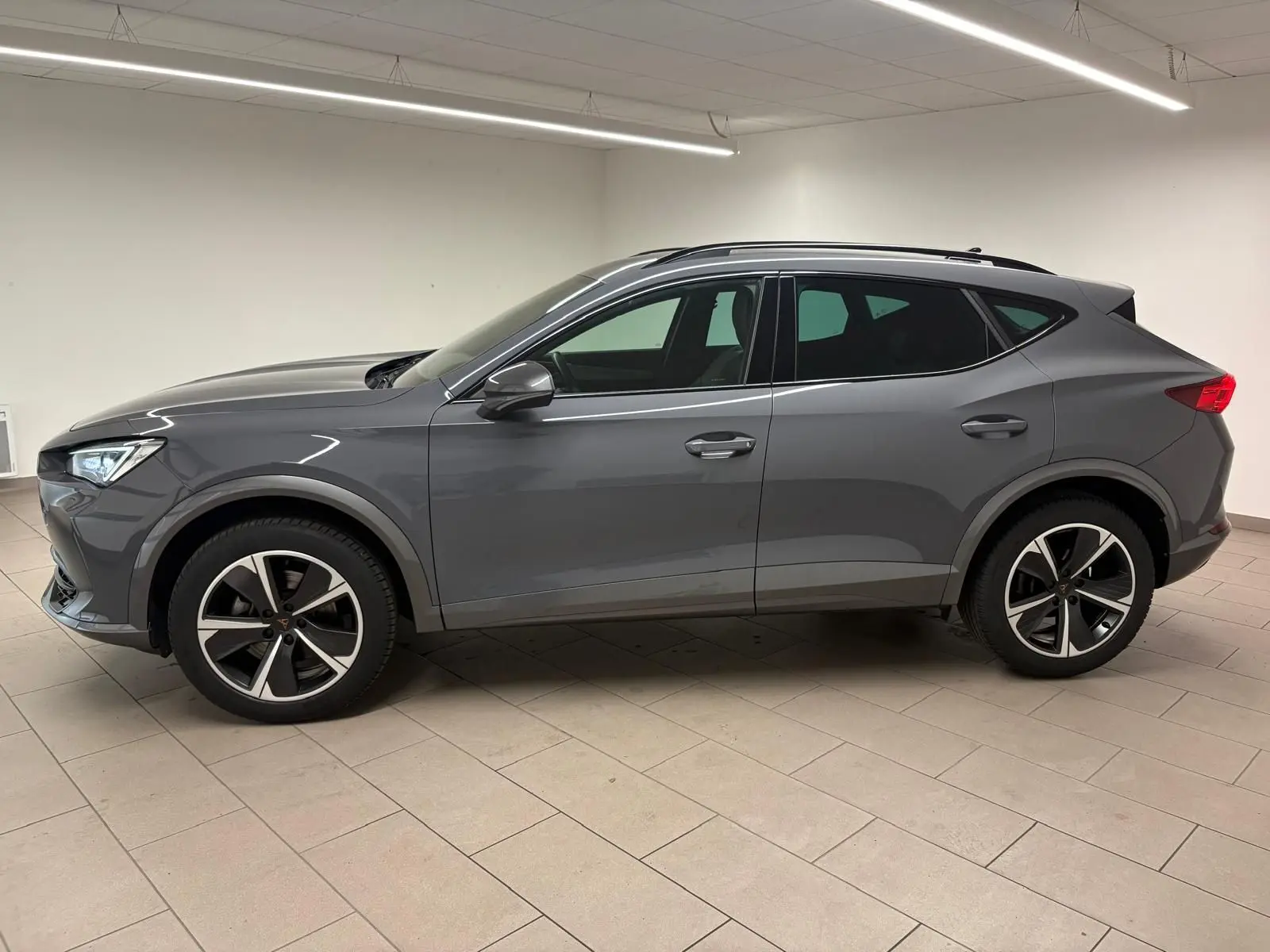 Vue de profil côté gauche du CUPRA Formentor 1.5 TSI 150 DSG7 en gris Graphène avec jantes 18'' Performance Aero.