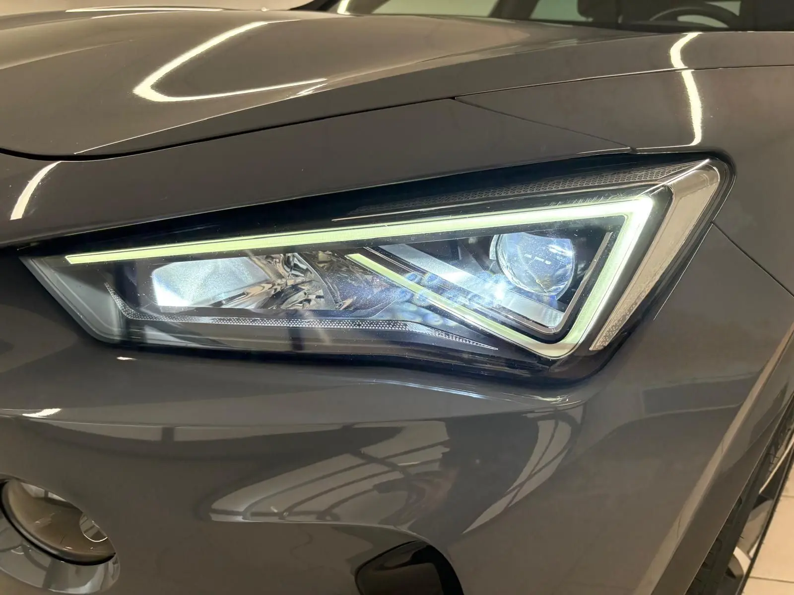 Gros plan sur le phare avant droit du CUPRA Formentor 1.5 TSI gris Graphène avec éclairage LED distinctif.