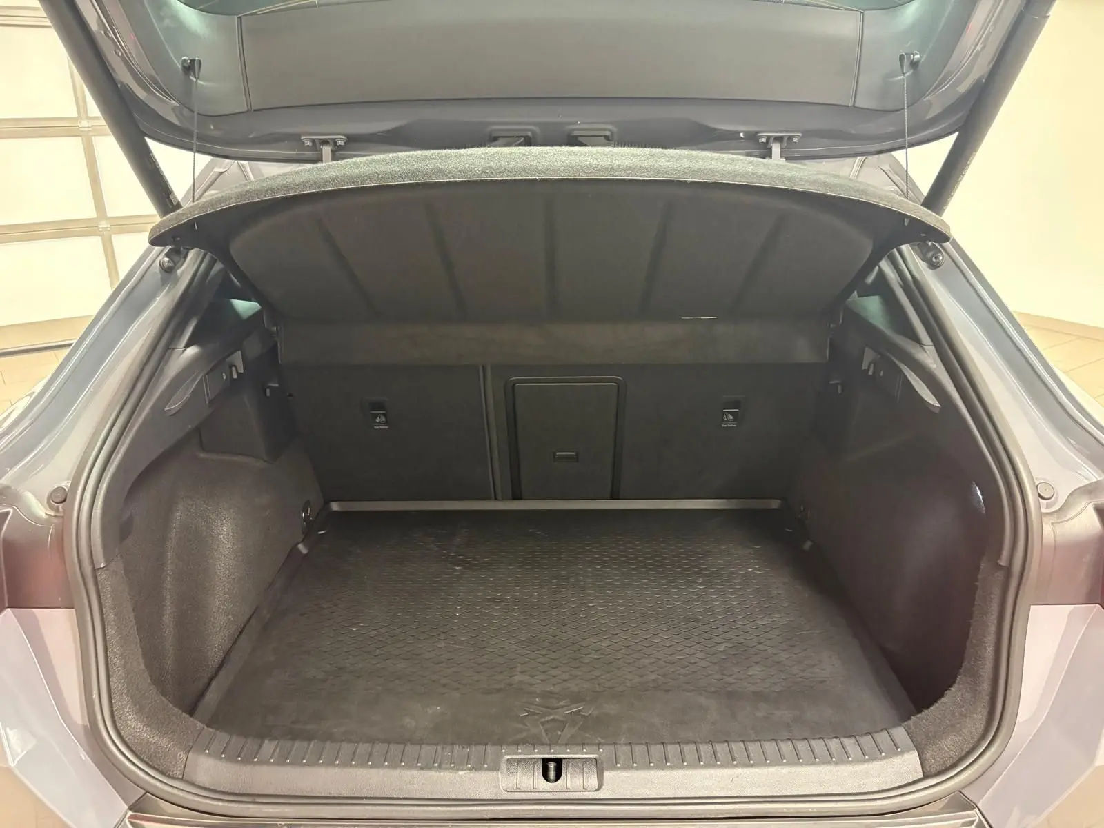 Coffre ouvert vu de l'arrière d'une CUPRA Formentor gris Graphène, montrant l'espace de chargement et la tablette arrière relevée.