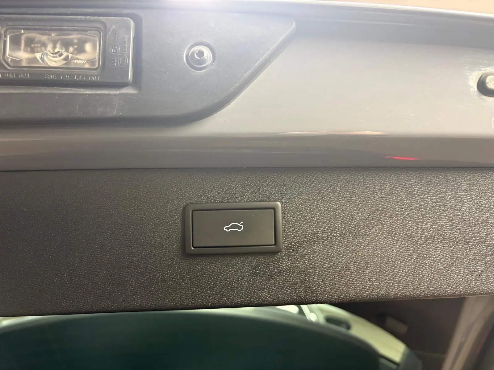 Bouton d'ouverture électrique du hayon sur la face intérieure d'un CUPRA Formentor gris Graphène, vue rapprochée.