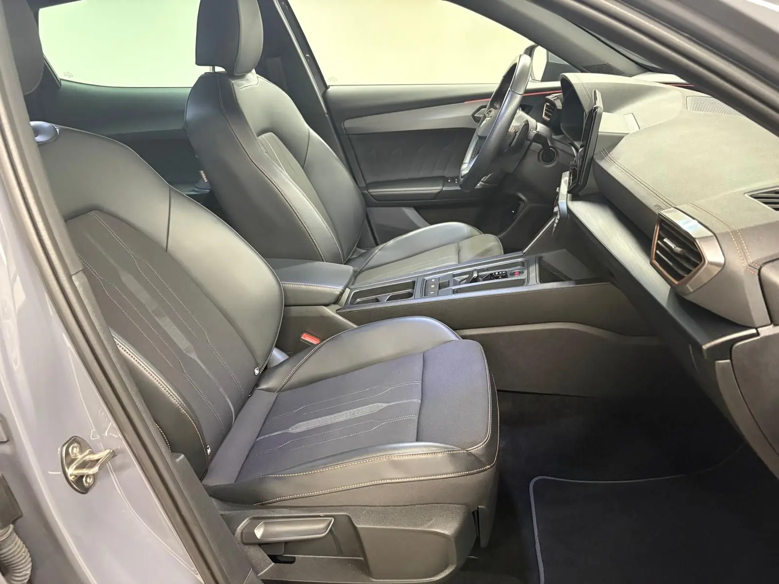 Vue intérieure côté conducteur du CUPRA Formentor 1.5 TSI 2022, sièges noirs avec surpiqûres contrastantes et tableau de bord moderne.