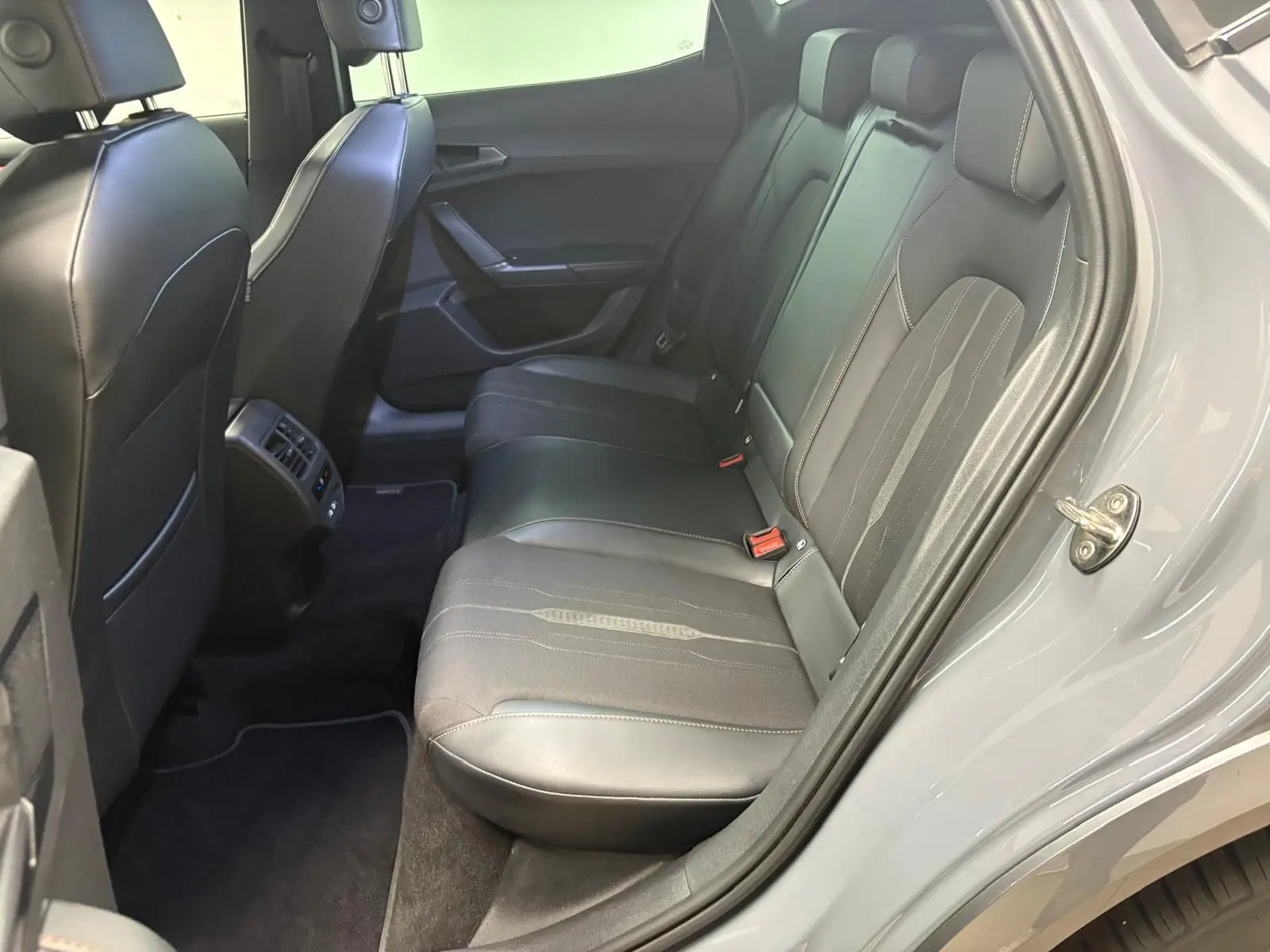 Vue intérieure côté droit des sièges arrière en cuir noir du CUPRA Formentor Gris Graphène avec aérateurs centraux.