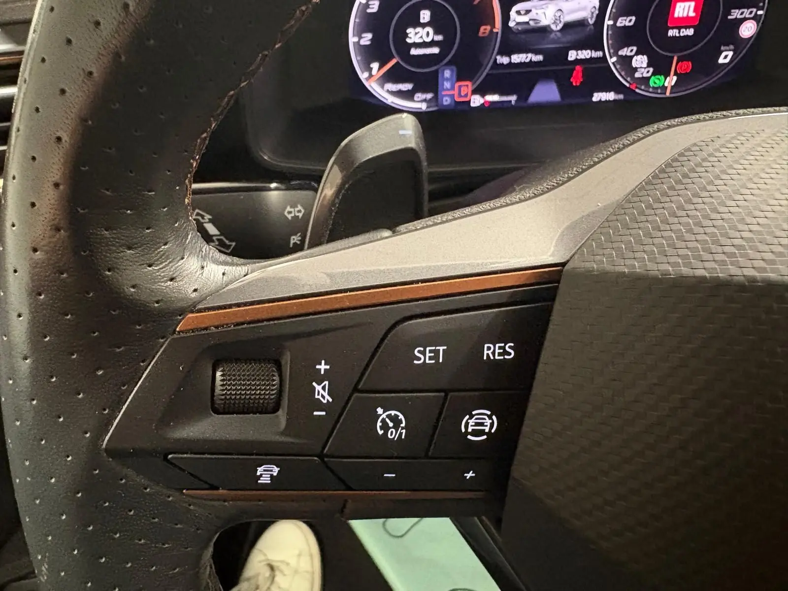 Gros plan sur les commandes au volant côté gauche du CUPRA Formentor gris Graphène, affichage numérique en arrière-plan.