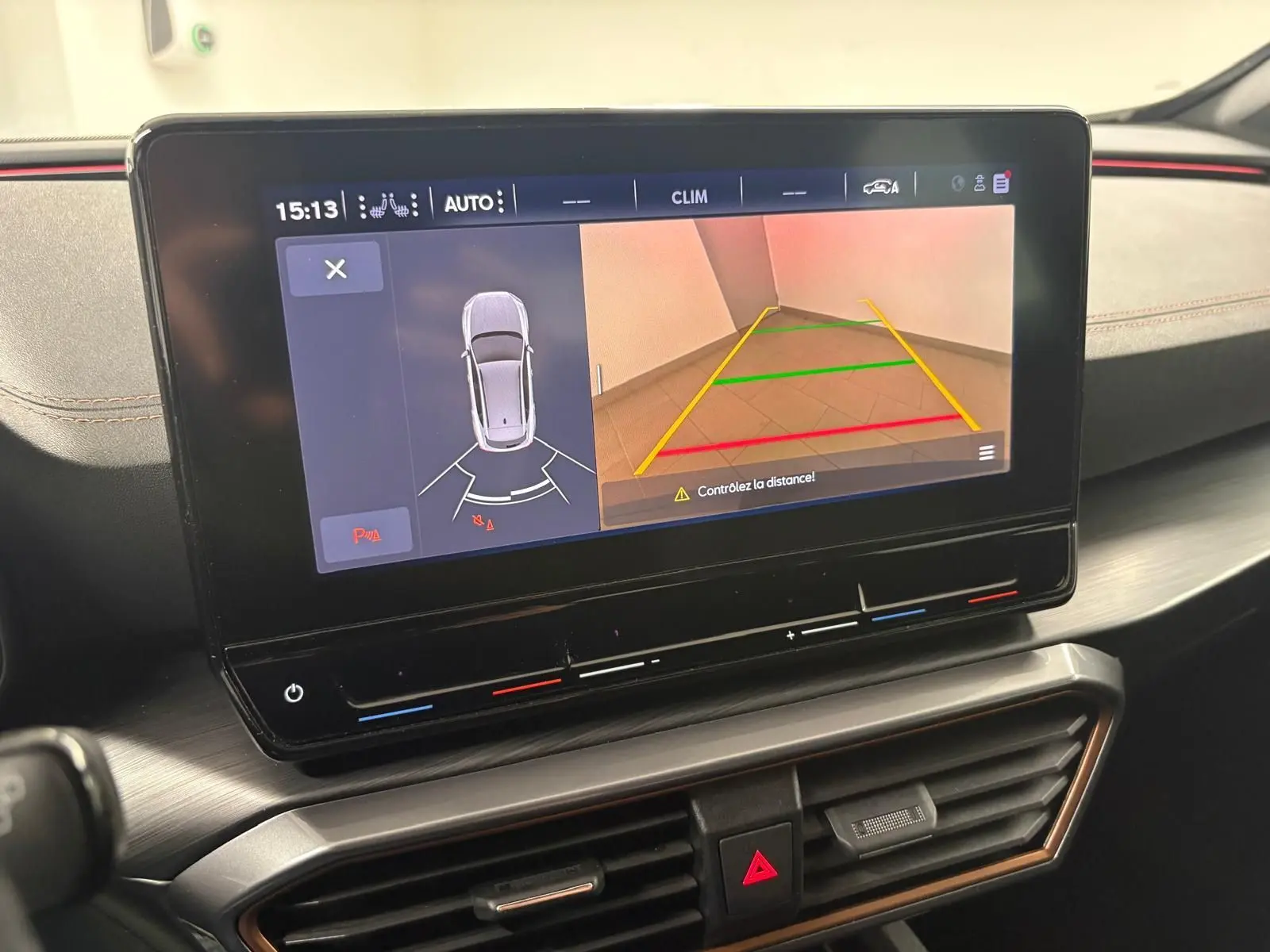 Vue intérieure du tableau de bord de la CUPRA Formentor 1.5 TSI 150 DSG7 avec écran de caméra de recul et climatisation digitale.