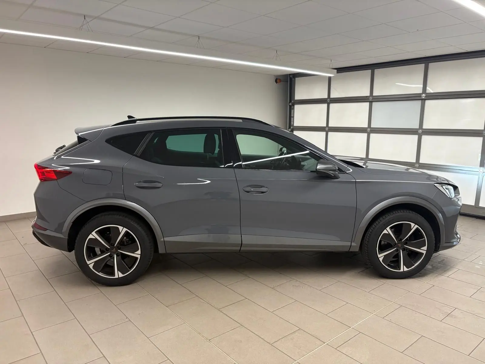 Vue de profil côté gauche d'un CUPRA Formentor 1.5 TSI 150 DSG7 en gris Graphène avec jantes alliage 18'' Performance Aero.