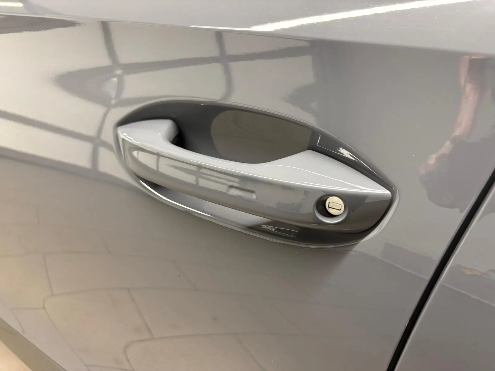 Poignée de porte côté gauche du CUPRA Formentor 1.5 TSI 150 DSG7 en gris Graphène avec serrure visible.