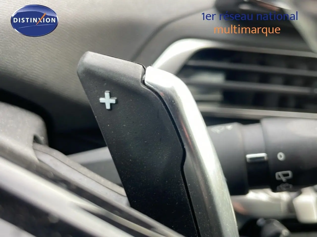 Gros plan sur la palette de changement de vitesse "+" côté droit du volant d'un Peugeot 3008 hybride rechargeable 2024.