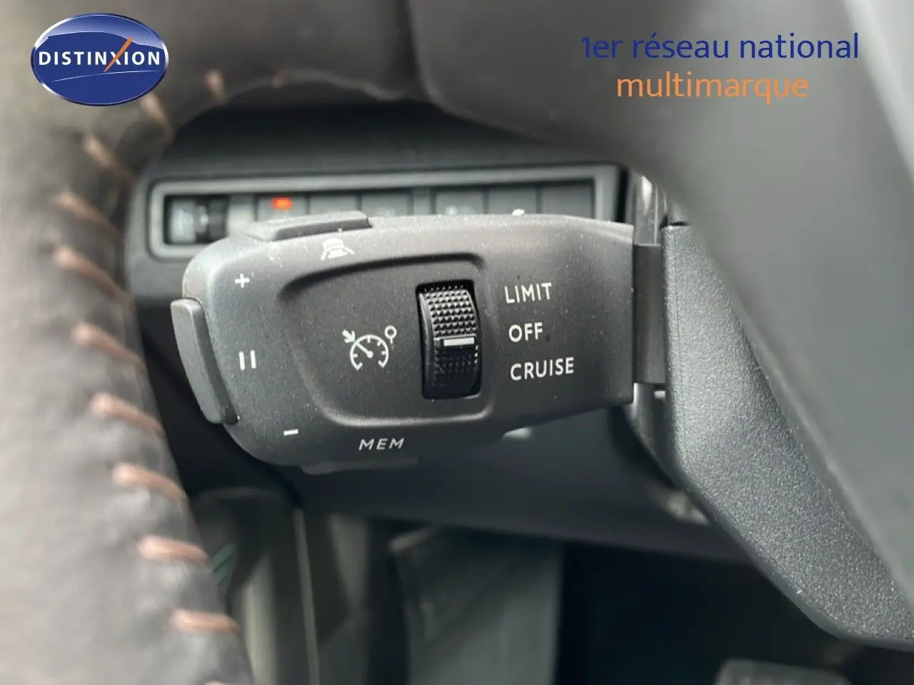 Gros plan sur la commande de régulateur de vitesse du Peugeot 3008 hybride rechargeable, volant partiellement visible.
