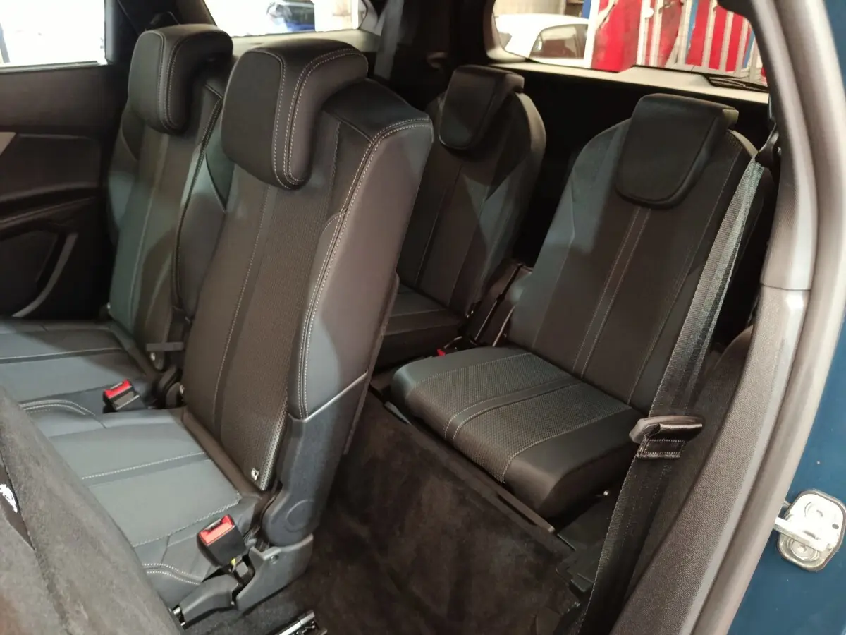 Vue intérieure côté droit montrant les sièges arrière noirs du Peugeot 5008 PureTech 130 GT bleu 2023.