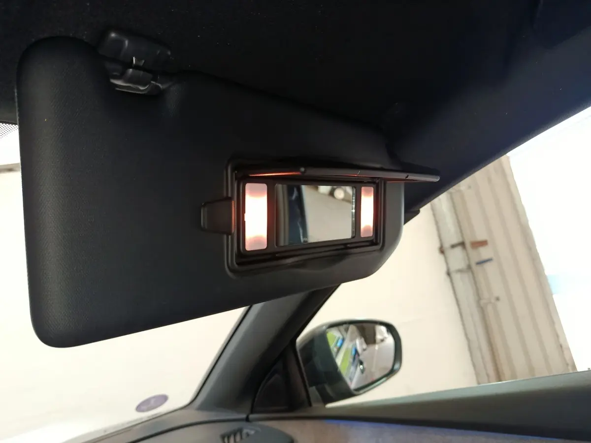 Détail du pare-soleil côté gauche avec miroir éclairé à l'intérieur d'un Peugeot 5008 bleu 2023.