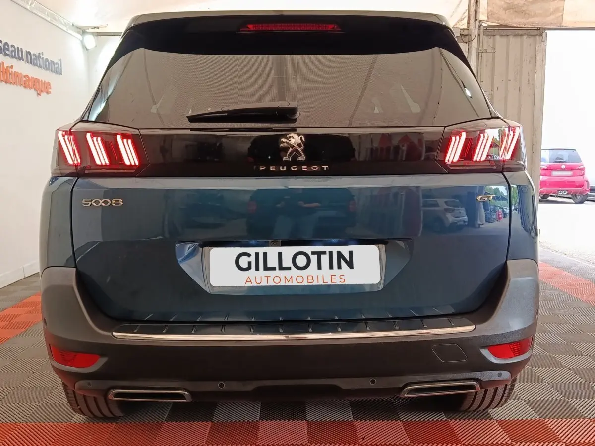 Vue arrière d’un Peugeot 5008 bleu 2023 avec feux LED distinctifs et double sortie d’échappement chromée.