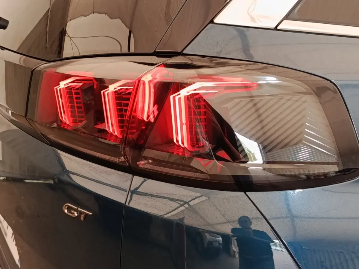Gros plan sur le feu arrière droit rouge et le logo GT du Peugeot 5008 bleu, version PureTech 130 S&S EAT8 GT.