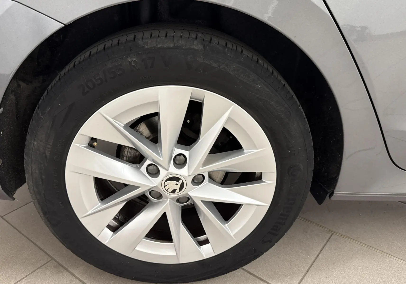 Gros plan sur la roue avant gauche de la Skoda Octavia Combi gris graphite 2023 avec jante alliage à dix branches.