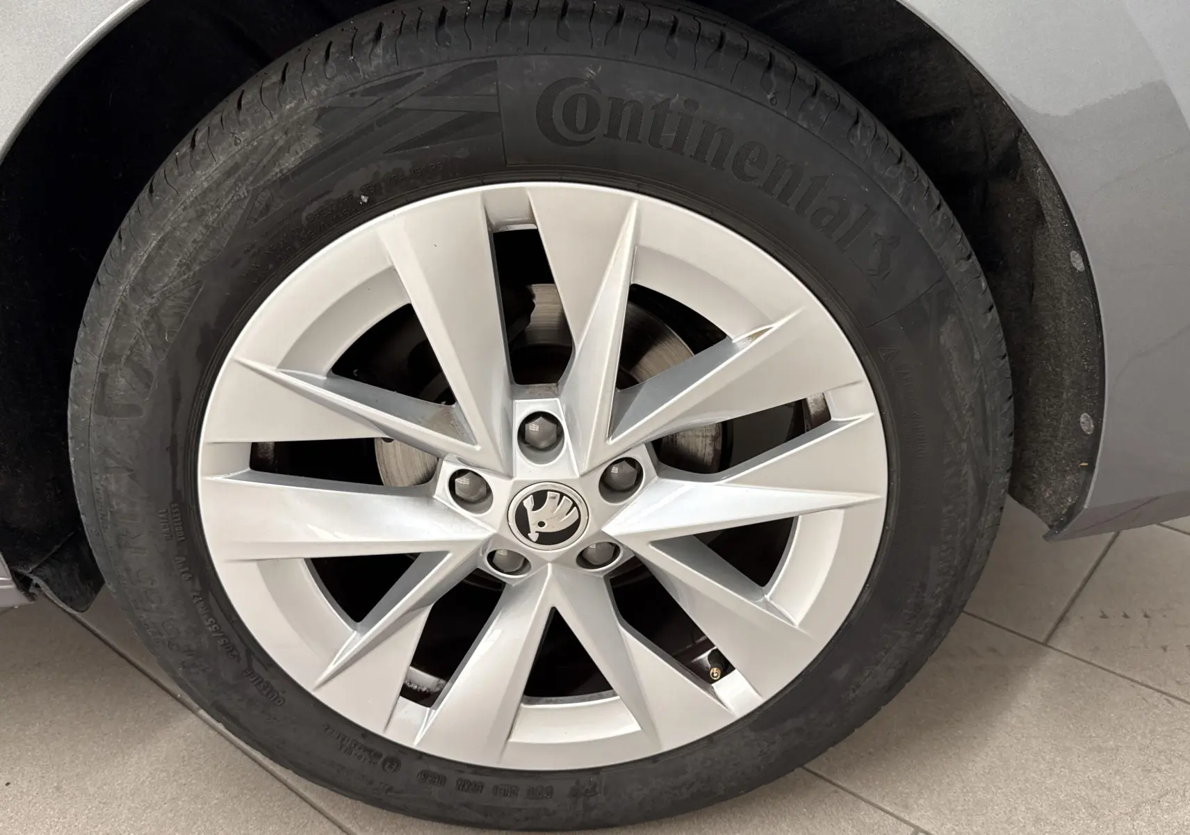 Gros plan sur la roue avant droite d'une Skoda Octavia Combi gris graphite, jante alliage à dix branches.