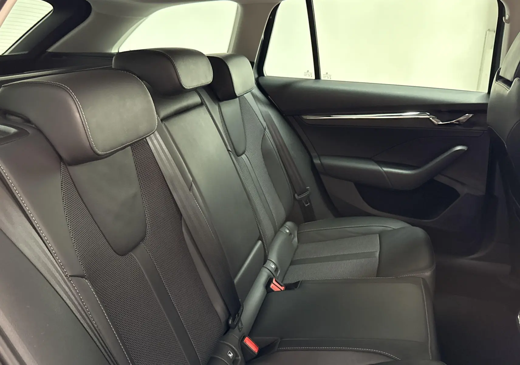 Vue intérieure côté droit des sièges arrière en cuir noir de la Skoda Octavia Combi 2023 gris graphite.
