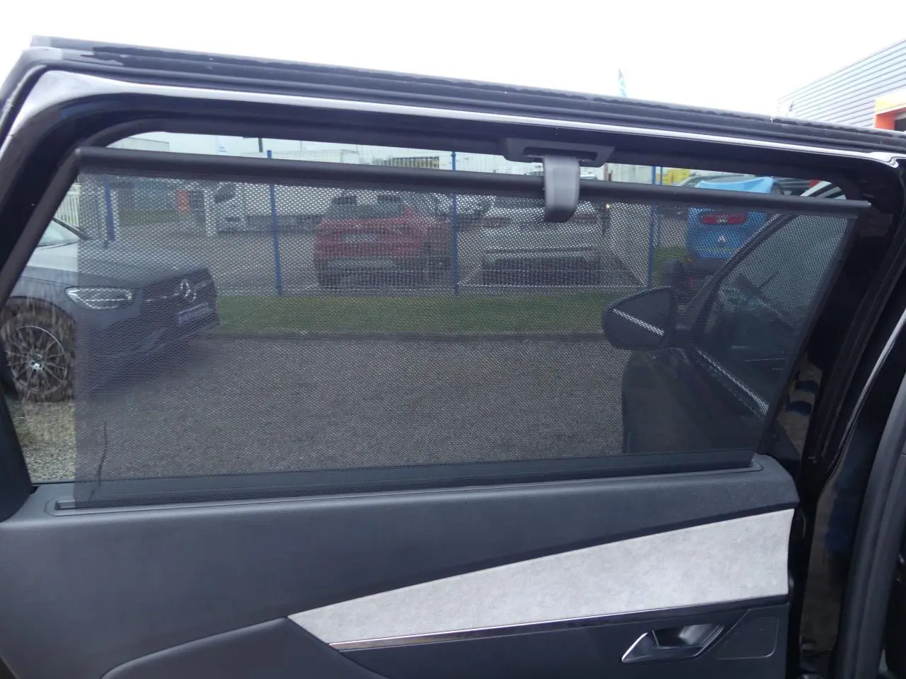 Store pare-soleil déployé sur la porte arrière côté droit d'un Peugeot 5008 noir métallisé 2023 GT