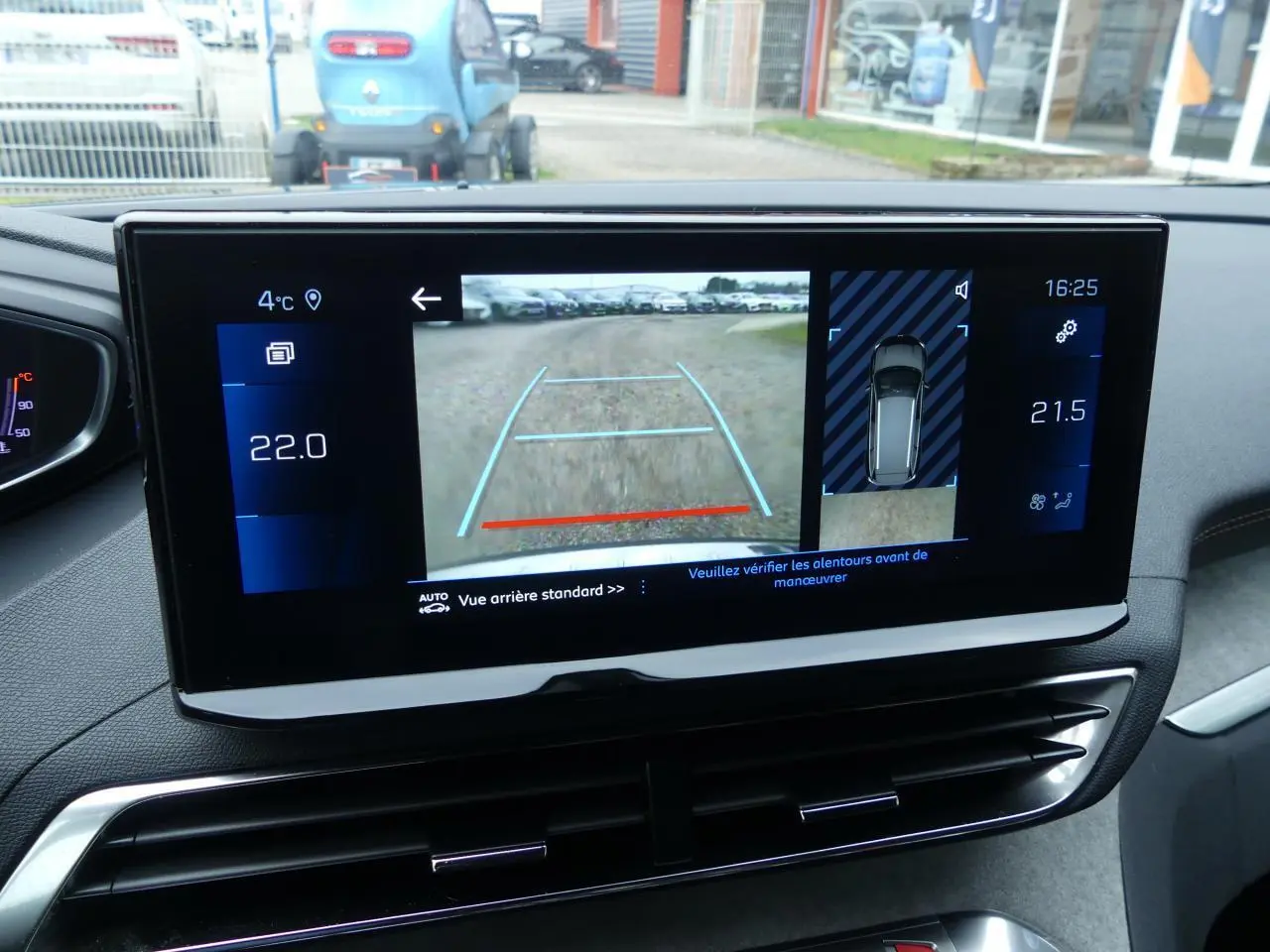 Écran tactile du tableau de bord du Peugeot 5008 GT 2023 montrant la caméra de recul et les réglages de climatisation.