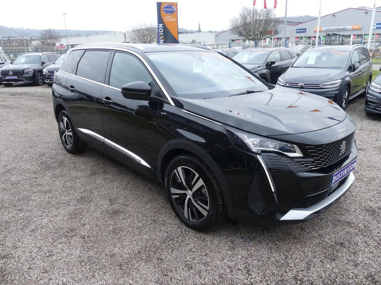 Peugeot 5008 GT noir métallisé vue 3/4 avant droit, avec jantes alliage bi-ton et calandre chromée distinctive.