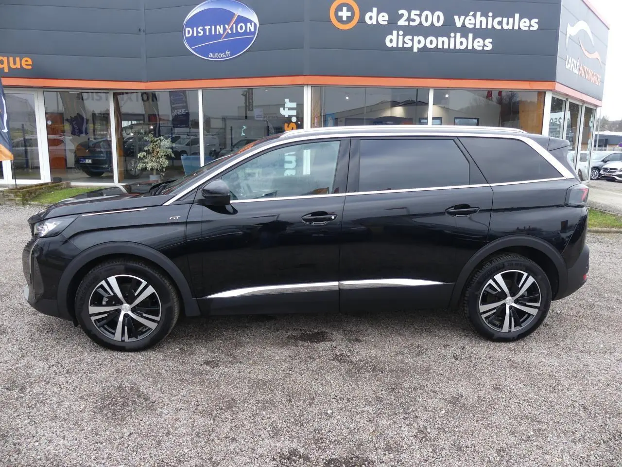 Profil côté gauche du Peugeot 5008 GT noir métallisé avec jantes alliage bicolores et vitres surteintées.