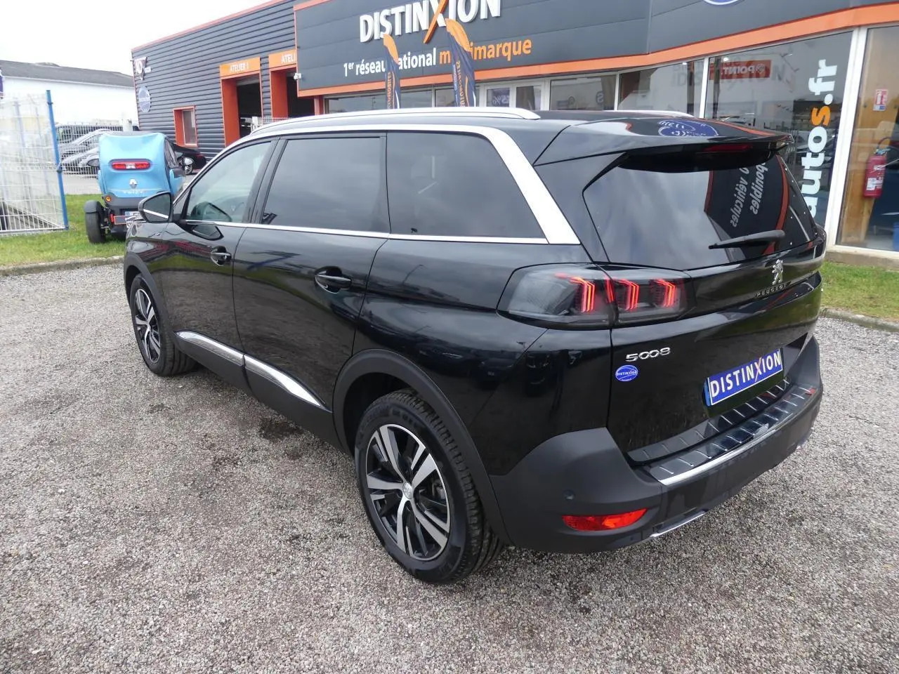 Peugeot 5008 GT noir métallisé vue 3/4 arrière droit avec jantes bi-ton et vitres surteintées.