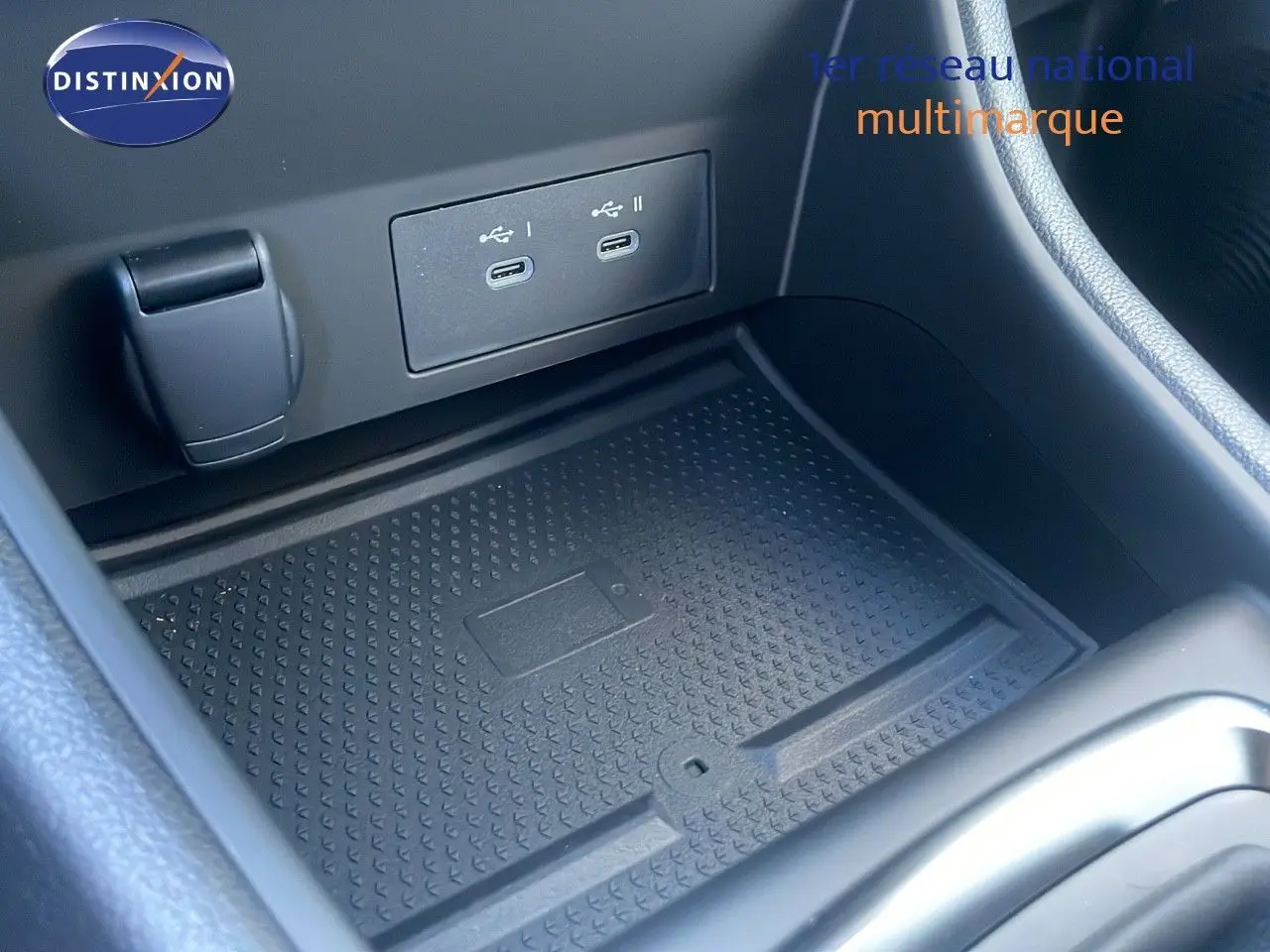 Gros plan sur la console centrale du Renault Captur E-Tech avec deux ports USB-C et un espace de rangement noir.