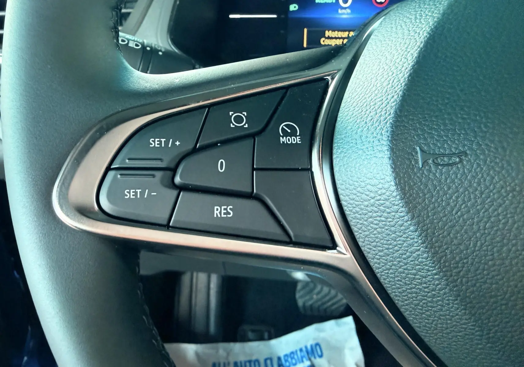 Gros plan sur les commandes au volant gauche du Renault Captur E-Tech hybride 2025, volant cuir noir.