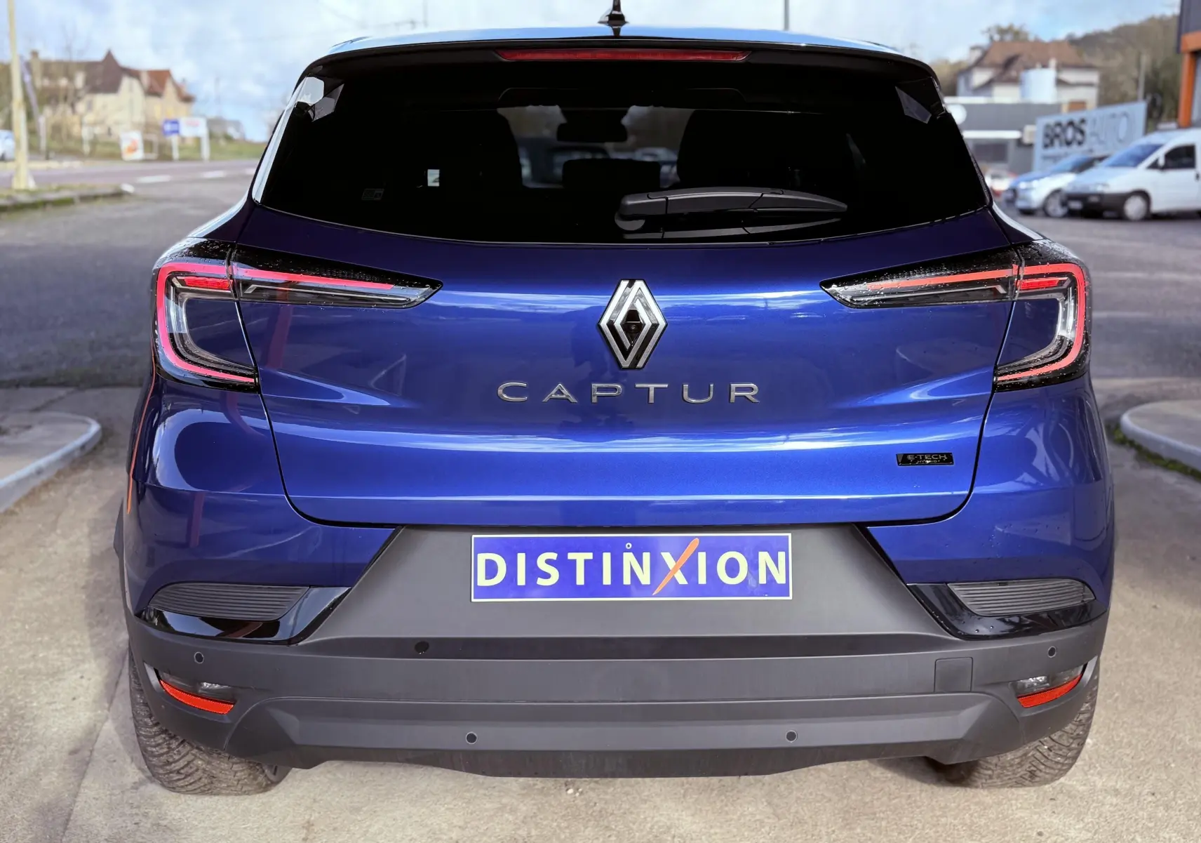 Vue arrière du Renault Captur 2025 bleu Iron Metal avec toit noir, mettant en valeur ses feux LED et logo distinctif.