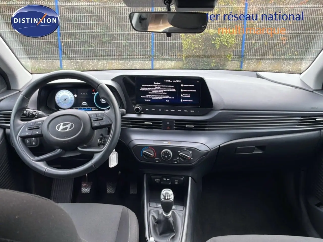 Vue intérieure avant de la Hyundai i20 2025 noir Phantom Metal, tableau de bord moderne avec écran tactile et boîte manuelle.