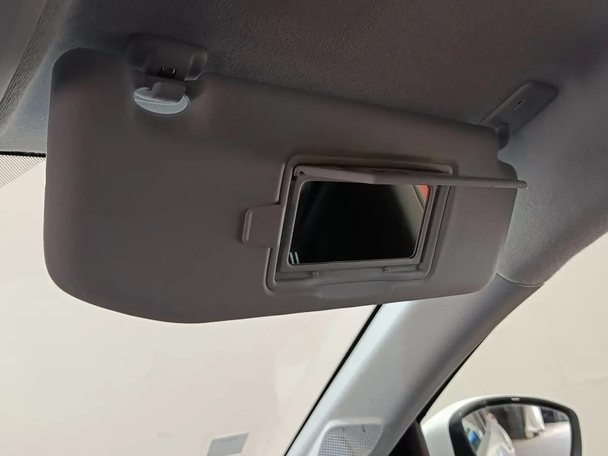 Détail de pare-soleil avec miroir intégré côté conducteur dans l'habitacle d'une Peugeot 208 blanche.