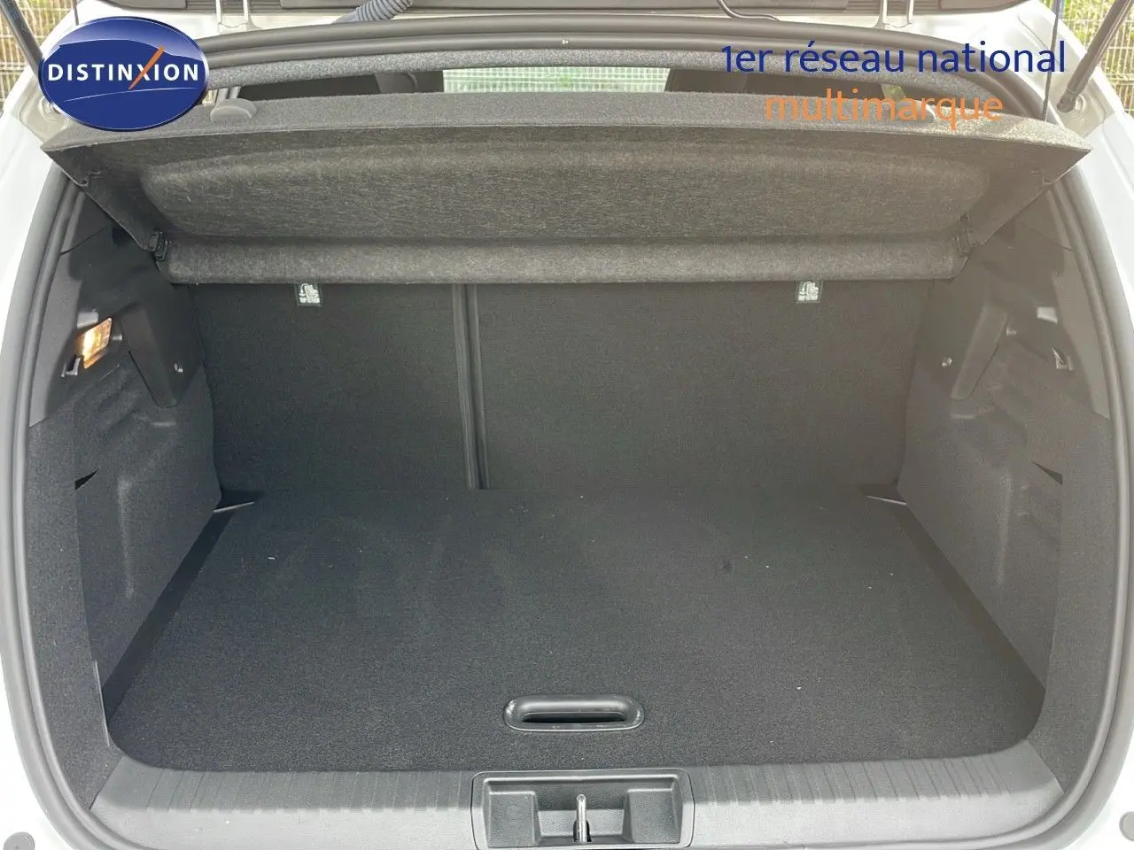 Coffre ouvert d'un Renault Captur blanc nacré avec toit beige, vue arrière montrant l'espace de chargement vide.