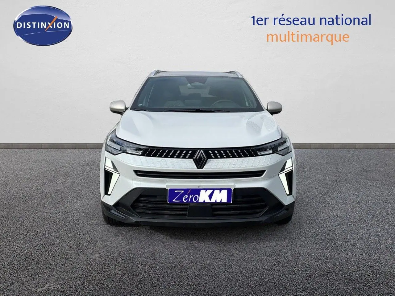 Vue avant du Renault Captur E-Tech hybride blanc nacré avec toit beige, mettant en valeur sa calandre et ses feux LED distinctifs.