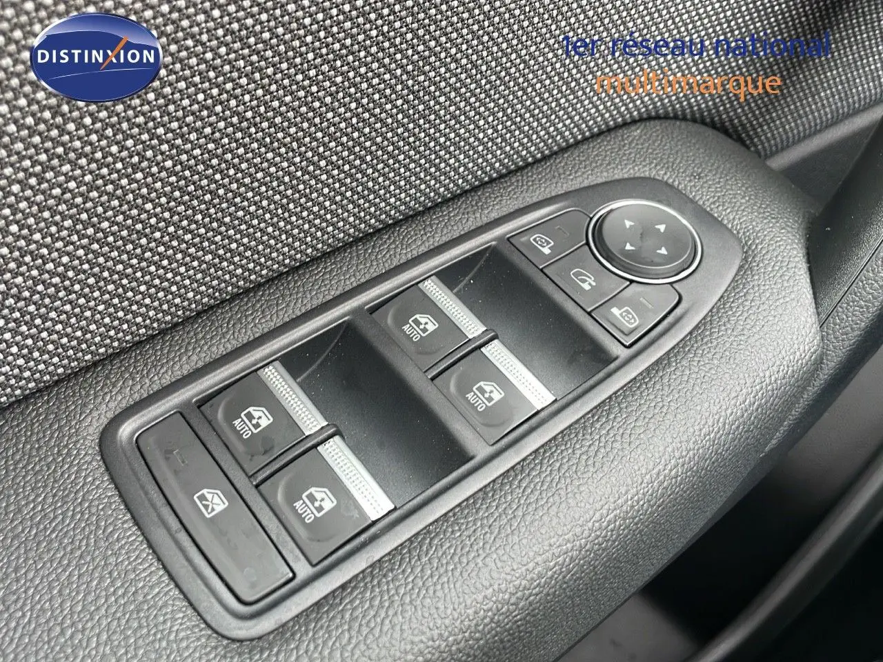 Gros plan sur les commandes de lève-vitres et rétroviseurs côté conducteur d'une Renault Captur 2025.