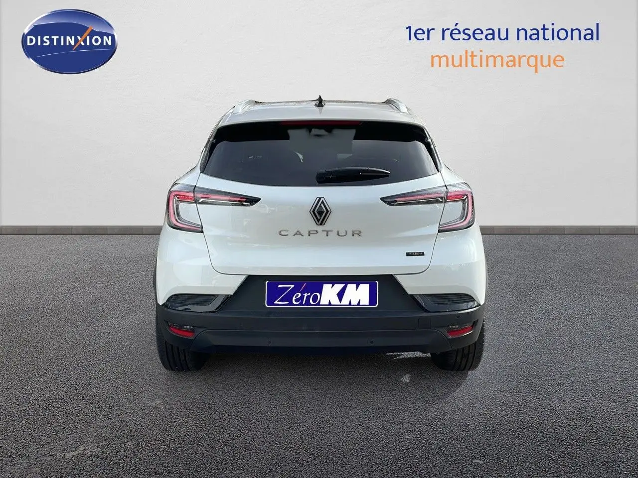 Vue arrière d'un Renault Captur blanc nacré avec toit beige, mettant en valeur ses feux LED et son logo central.