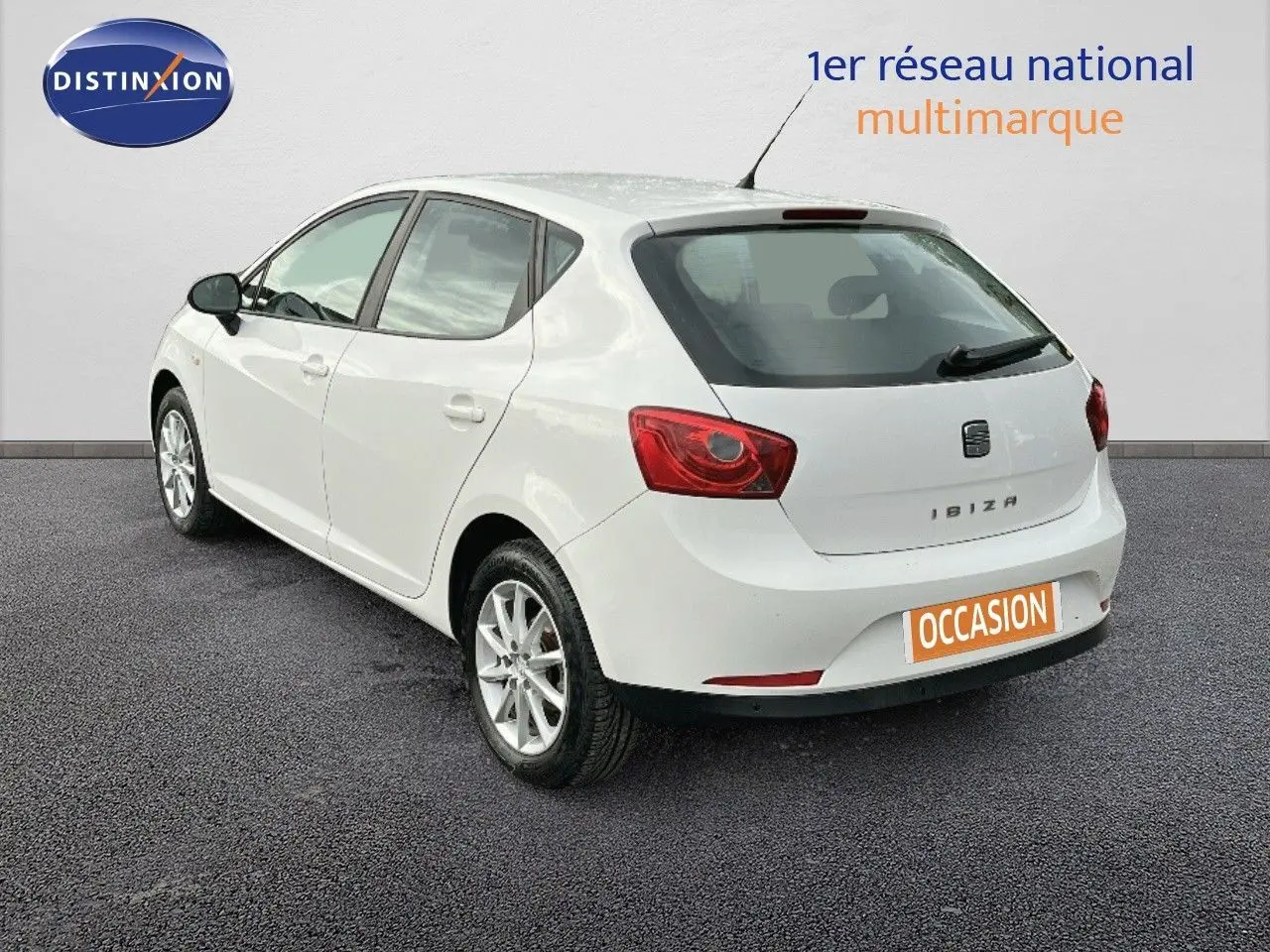 SEAT IBIZA blanche vue en 3/4 arrière côté gauche, avec feux arrière rouges et plaque "OCCASION" visible.