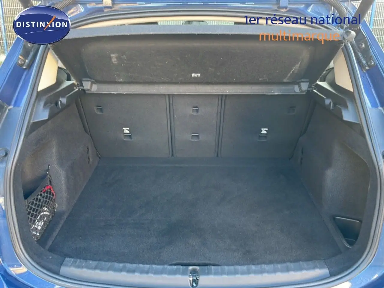 Coffre ouvert d’une BMW Série 2 Active Tourer bleu phytonique, vue arrière montrant un espace de chargement propre et spacieux.