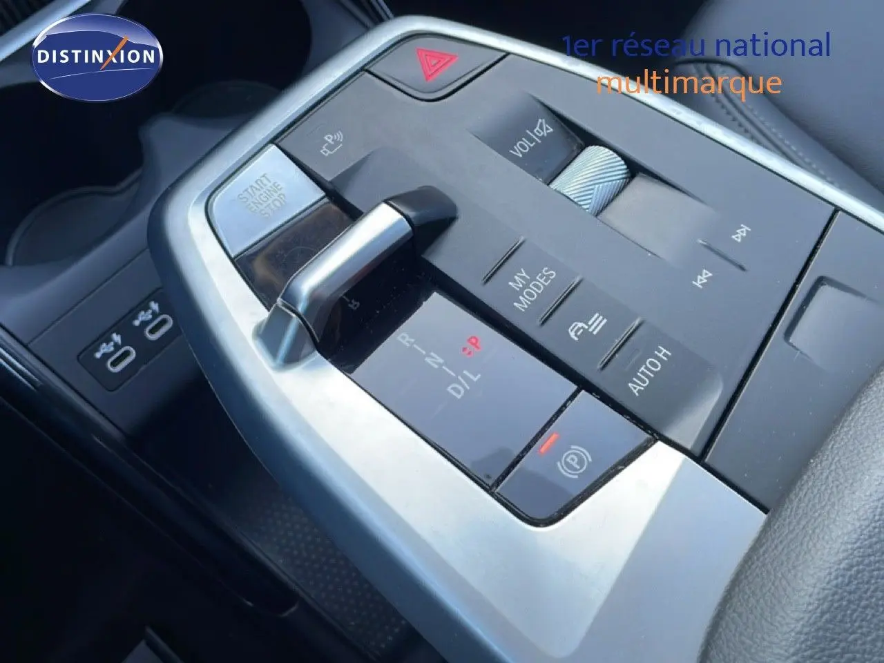 Gros plan sur la console centrale avec levier de vitesse automatique et commandes multimédia d'une BMW Série 2 Active Tourer.