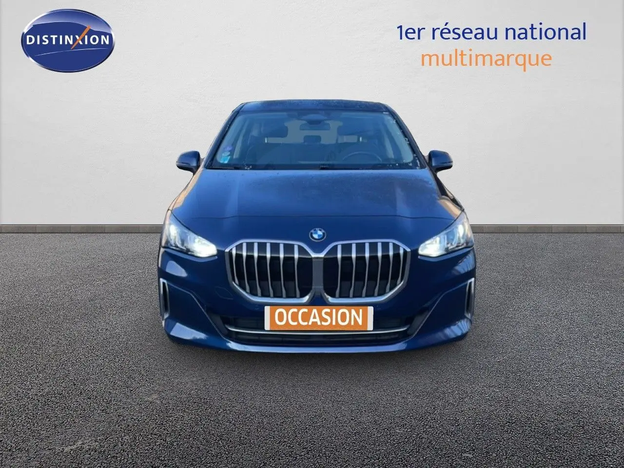 Vue frontale d'une BMW Série 2 Active Tourer 218i bleu phytonique métallisé avec calandre imposante et phares allumés.