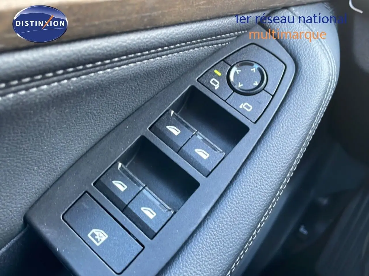 Gros plan sur les commandes de lève-vitres et rétroviseurs côté gauche en cuir noir de la BMW Série 2 Active Tourer bleu Phytonique.