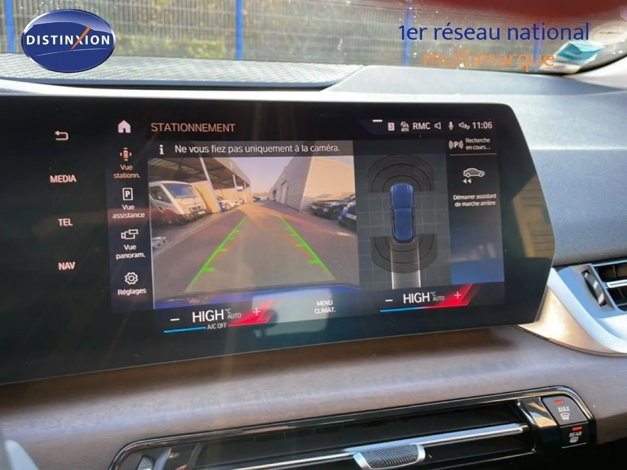 Écran central de BMW Série 2 Active Tourer 218i bleu phytonique, affichant la caméra de recul et l'assistance au stationnement.