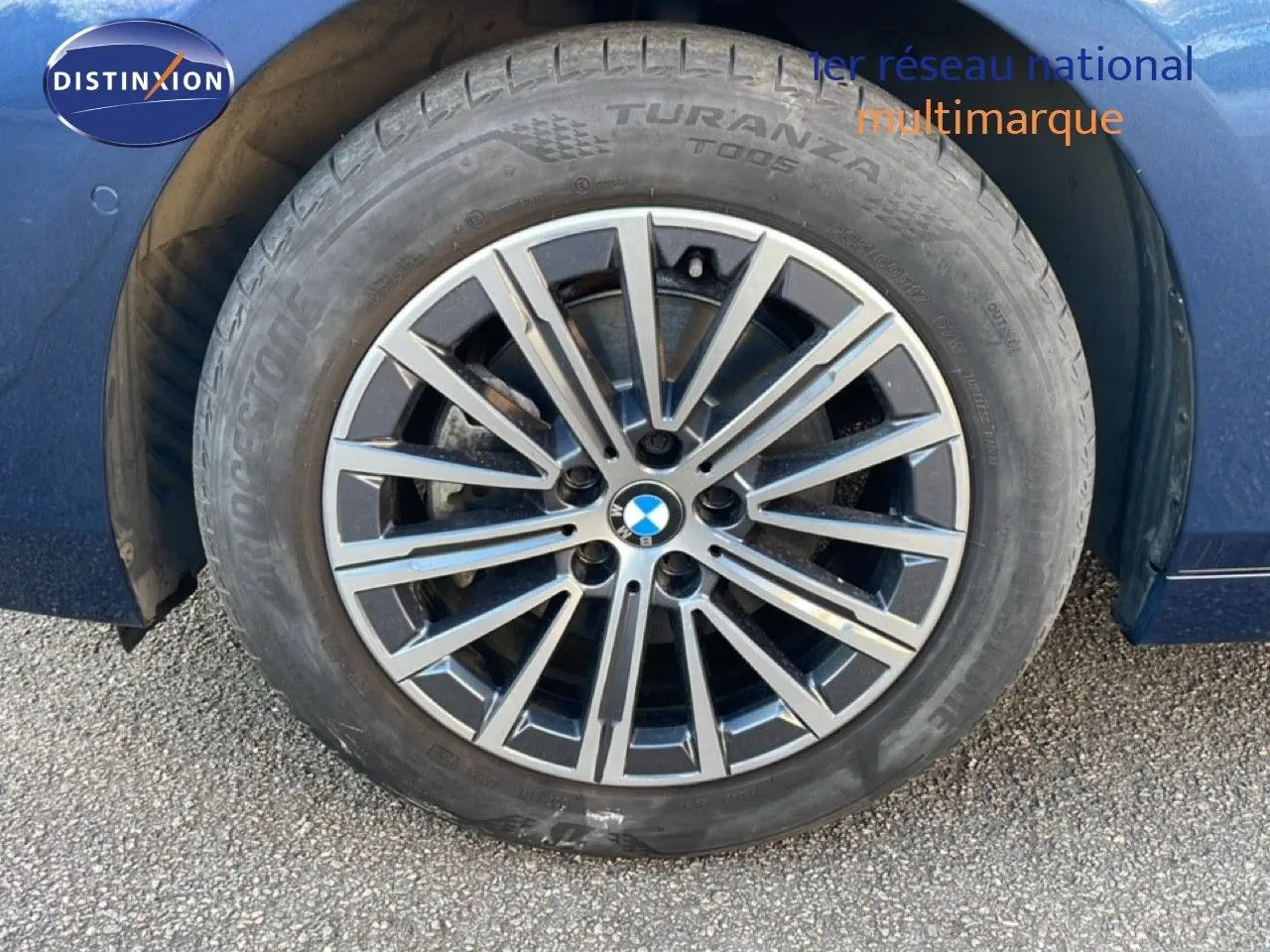 Gros plan sur la roue avant gauche d'une BMW Série 2 Active Tourer bleu phytonique avec jante alliage multibranches.